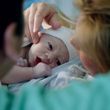 Photo d'un bébé dans les bras de sa maman